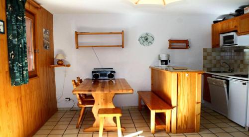 une cuisine avec une table en bois et une radio. dans l'établissement Résidence Le Chardonnet - Appartement à 200 m des psites avec belle vue MAE-3276, à Champagny-en-Vanoise