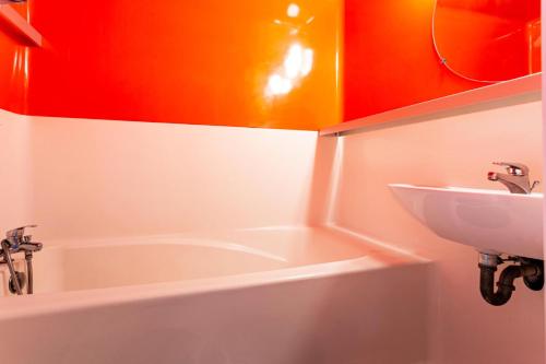 une salle de bain avec un lavabo et une baignoire dans l'établissement Résidence les Lauzières - maeva Home - Studio 5 personnes - Confort MAE-4424, à Arc 1800