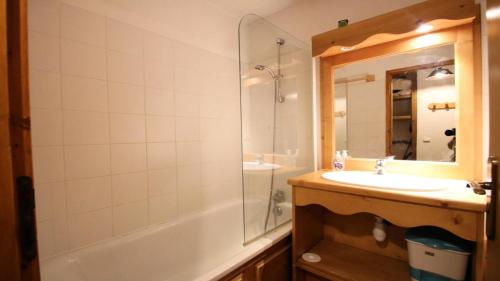 a bathroom with a sink and a tub and a mirror at Résidence Dame Blanche - Chalets pour 6 Personnes 721 in Narreyroux
