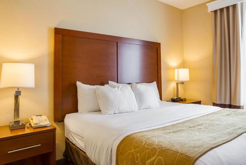 a hotel room with a bed and a telephone at Comfort Suites in Twinsburg