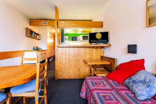 Cette chambre comprend un lit, une table et une cuisine. dans l'établissement Résidence Pierra Menta - maeva Home - Studio 5 personnes - Confort MAE-2344, à Arc 1800