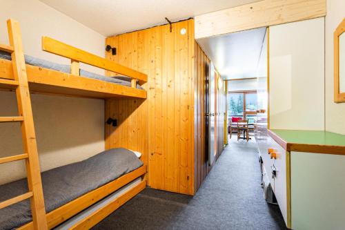 Ce dortoir comprend des lits superposés et une table. dans l'établissement Résidence Pierra Menta - maeva Home - Studio 5 personnes - Confort MAE-2344, à Arc 1800