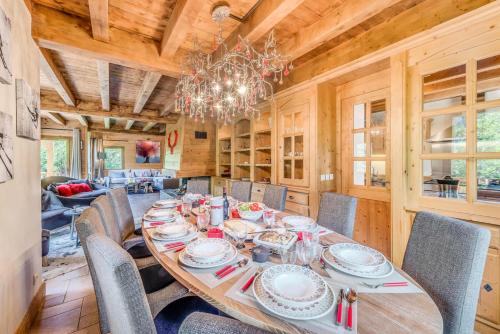 une salle à manger avec une table, des chaises et un lustre dans l'établissement Chalet Alideale - Chalet familial de haut standing MAE-3283, à Champagny-en-Vanoise