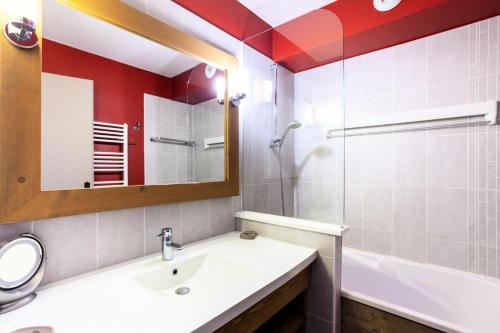 a bathroom with a sink and a mirror and a tub at Résidence Le Christiana - maeva Home - Appartement 2 Pièces 5 Personnes - Sélection MAE-3814 in Saint-Bon-Tarentaise