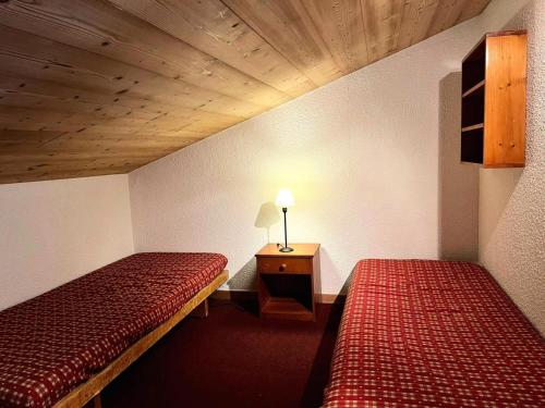 une chambre avec deux lits et une table avec une lampe dans l'établissement Résidence Clairiere - La Clairière 27 - Spacieux et confortable duplex, classé 3 étoiles MAE-4854, à Valmorel