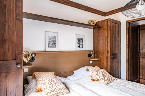 une chambre avec un lit avec une tête de lit en bois dans l'établissement Résidence Les Arcs 1950 Le Village - maeva Home - Appartement 3 pièces 6 personnes - Prestige MAE-8554, à Bourg-Saint-Maurice