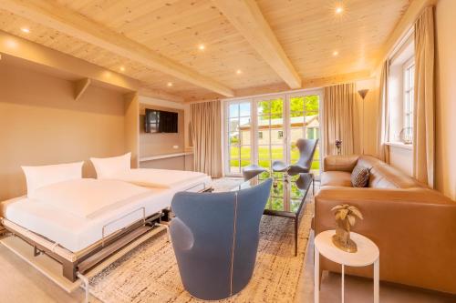 a bedroom with a bed and a couch at Michels Ferienhaus Amalie in Archsum