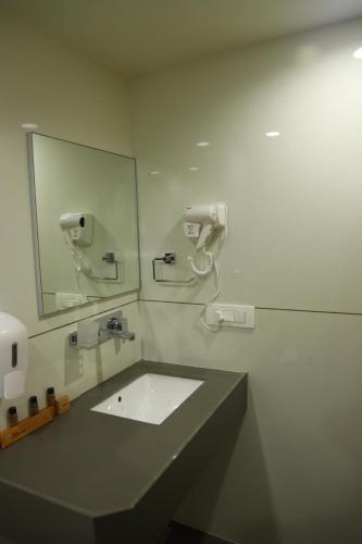 a bathroom with a sink and a mirror at Hotel Lake Point in Ahmedabad