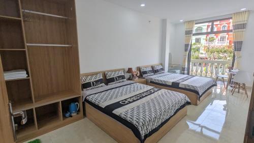 two beds in a room with a window at Thiên Ý Homestay in Phu Quoc