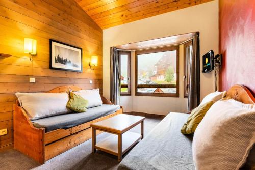 a living room with a couch and a window at Quartier La Forêt - maeva Home - Appartement 2 pièces 5 personnes - Sélection MAE-3904 in Valmorel