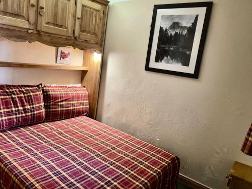 Cette chambre dispose d'un lit et d'une photo murale. dans l'établissement Résidence Valeriane - La Valériane 212 - Joli 3 pièces, vue magnifique sur les montagnes MAE-5194, à Valmorel