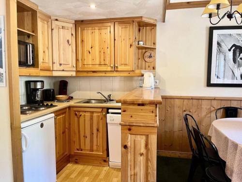 une cuisine avec des placards en bois et un appareil blanc dans l'établissement Résidence Valeriane - La Valériane 212 - Joli 3 pièces, vue magnifique sur les montagnes MAE-5194, à Valmorel