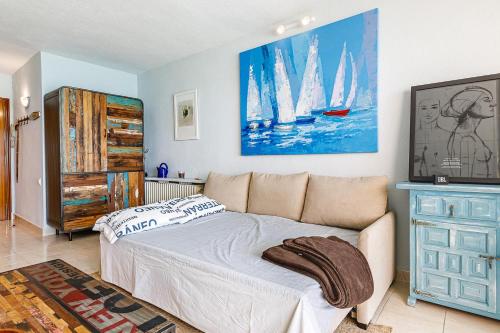 ein Schlafzimmer mit einem Bett und einem Sofa und einem Gemälde in der Unterkunft Cap Negret Altea Mar in Altea