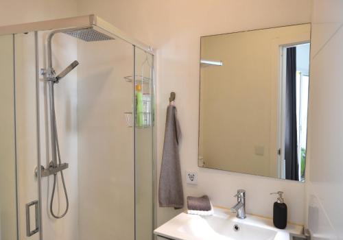 y baño con ducha, lavabo y espejo. en Ático Moderno - Out of Blue, en Santa Cruz de la Palma