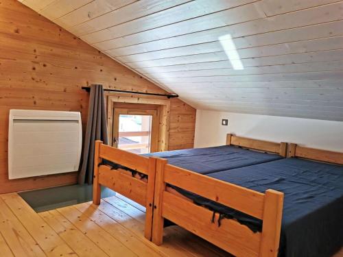 une chambre avec un lit dans une cabane en bois dans l'établissement Résidence Lauziere Dessous - La Lauzière Dessous 50 - Triplex offrant charme et modernité MAE-5134, à Valmorel