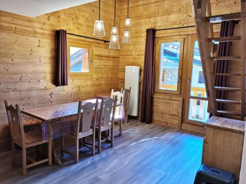 d'une salle à manger avec une table et quelques fenêtres. dans l'établissement Résidence Lauziere Dessous - La Lauzière Dessous 50 - Triplex offrant charme et modernité MAE-5134, à Valmorel