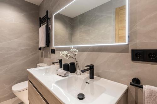 y baño con lavabo blanco y espejo. en MH Apartments Soho Madrid, en Madrid