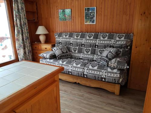- une chambre avec un lit et un canapé avec des oreillers dans l'établissement Résidence Le Chardonnet - 2 Pièces pour 6 Personnes MAE-3310, à Champagny-en-Vanoise