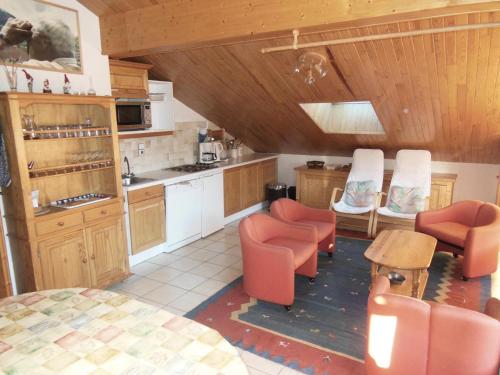 une cuisine avec des chaises orange et une table. dans l'établissement Résidence Le Roselin - 3 Pièces pour 6 Personnes MAE-3311, à Champagny-en-Vanoise