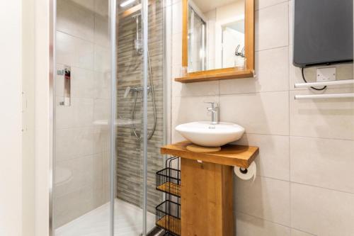 une salle de bain avec un lavabo et une douche dans l'établissement Résidence les Chardons - maeva Home - Appartement 2 pièces 5 personnes - Confort MAE-4014, à Arc 1800