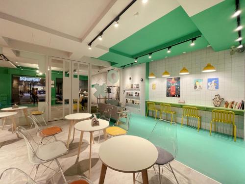 a restaurant with white tables and chairs and green ceilings at together hotel Hualien Zhongshan in Hualien City