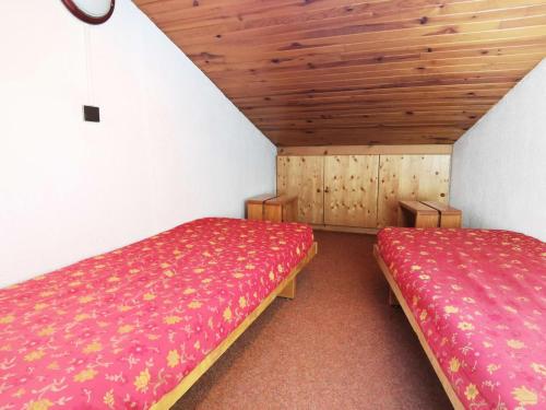 deux lits dans une chambre avec plafonds en bois dans l'établissement Résidence Clairiere - La Clairière 35 - Spacieux T4 avec mezzanine, calme, classé 3 étoiles MAE-5244, à Valmorel