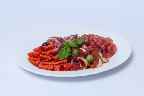 a white plate of food with meat and vegetables at Aristokrat in Vinnytsya