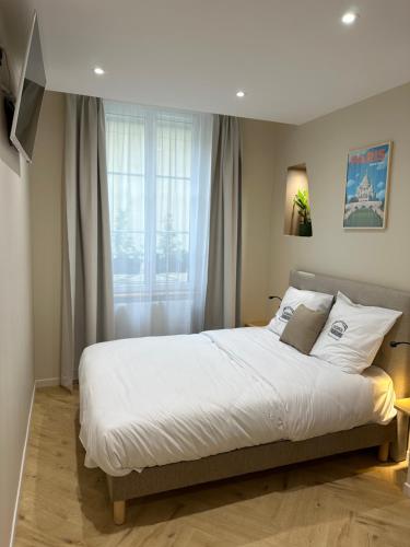 a bedroom with a large bed and a window at Les Chambres du Faubourg in Paris