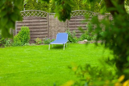 ein blauer Stuhl, der im Gras im Hof sitzt in der Unterkunft Ferienhaus OG2 "Bönsberg Blick" in Martinfeld
