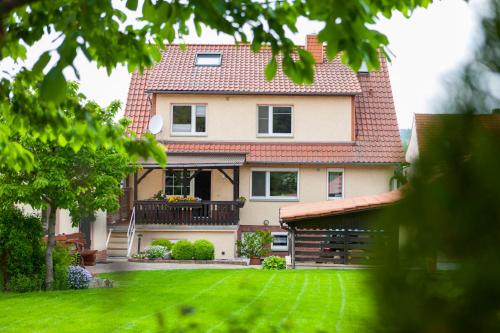 ein großes Haus mit einem Hof mit grünem Gras in der Unterkunft Ferienhaus OG2 "Bönsberg Blick" in Martinfeld