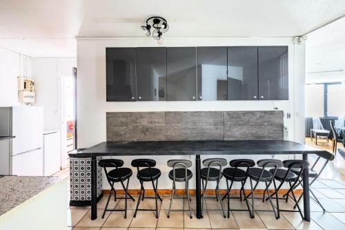 une cuisine avec un îlot noir et des tabourets de bar dans l'établissement Résidence Le Tourmalet - maeva Home - Appartement 3 pièces 9 personnes - Sélection MAE-3804, à La Mongie