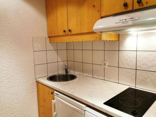 une petite cuisine avec un évier et une cuisinière dans l'établissement Résidence Lauzes - Les Lauzes 48 - Joli 2 pièces, vue pistes, classé 3 étoiles MAE-4944, à Valmorel