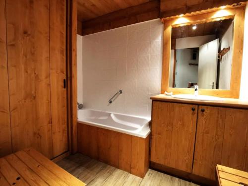 une salle de bain avec une baignoire, un lavabo et un miroir dans l'établissement Résidence Lauzes - Les Lauzes 48 - Joli 2 pièces, vue pistes, classé 3 étoiles MAE-4944, à Valmorel