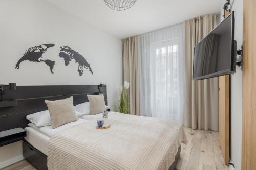 um quarto com uma cama e uma televisão de ecrã plano em Unique Baltic Marina Residence with Sauna & Fitness by Renters em Colberga