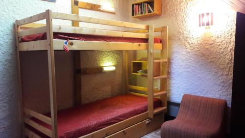 Cette chambre comprend 2 lits superposés et une chaise. dans l'établissement Résidence Les PrimevÈres - 3 Pièces pour 6 Personnes MAE-3301, à Champagny-en-Vanoise