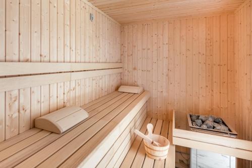 uma sauna de madeira com um banco e uma banheira em Unique Baltic Marina Residence with Sauna & Fitness by Renters em Colberga