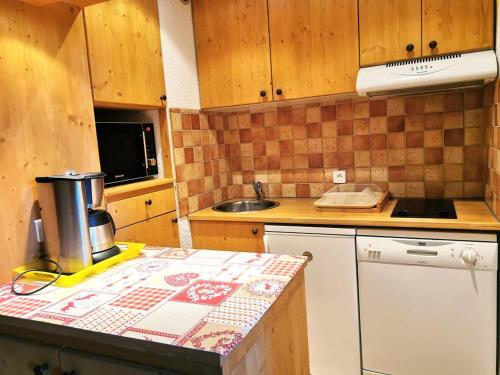 a kitchen with wooden cabinets and a counter top at Résidence CLAIRIERE - Studio pour 4 Personnes 04 in Valmorel