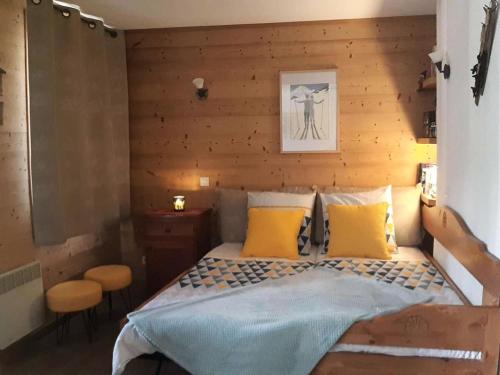 une chambre avec un lit avec des oreillers jaunes dans l'établissement Résidence Lauziere Dessous - La Lauzière-Dessous 22 - Joli 2 pièces divisible, ski aux pieds MAE-5444, à Valmorel