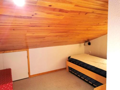 Cette chambre dispose d'un plafond en bois et de lits superposés. dans l'établissement Résidence CHEVAL BLANC - 3 Pièces pour 6 Personnes 64, à Valmorel