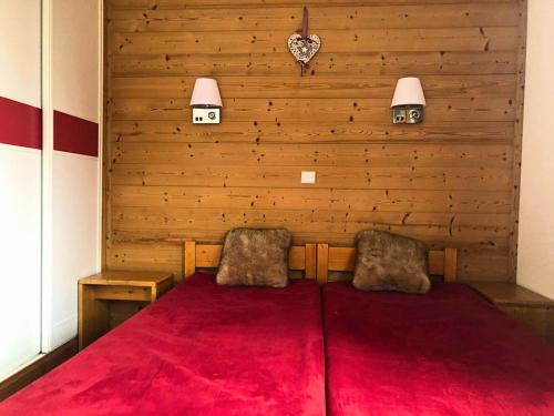 - une chambre dotée d'un mur en bois avec 2 lits et de moquette rouge dans l'établissement Résidence Camarine - La Camarine 30 - Agréable 2 pièces, au pied des pistes MAE-5464, à Valmorel