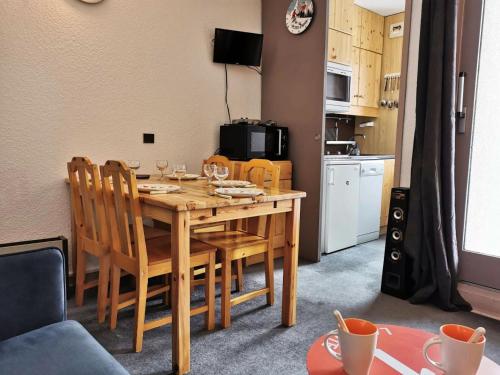 une table de salle à manger avec des chaises et une cuisine dans l'établissement Résidence Riondet - Le Riondet 5 - Agréable 2 pièces en rez de neige, vue magnifique MAE-5524, à Valmorel