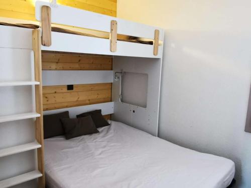 Ce lit superposé se trouve dans une petite chambre dotée d'un matelas blanc. dans l'établissement Résidence Riondet - Le Riondet 5 - Agréable 2 pièces en rez de neige, vue magnifique MAE-5524, à Valmorel