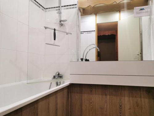 een badkamer met een bad, een wastafel en een spiegel bij Résidence Terrasse - La Terrasse 10 - Studio divisible au pied des pistes , magnifique vue MAE-5544 in Valmorel