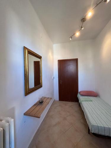 een kamer met een bed en een spiegel aan de muur bij ARCOBALENO 4 in Livorno