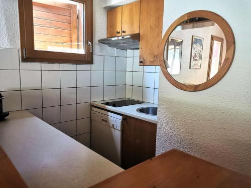 - une petite cuisine avec un évier et un miroir dans l'établissement Résidence Bourg Morel - Le Bourg-Morel 36/4 - Duplex rue piétonne MAE-5654, à Valmorel