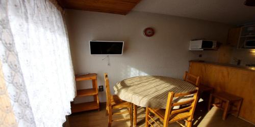 une table et des chaises dans une cuisine avec une table et une télévision dans l'établissement Résidence Le Centre - 2 Pièces pour 5 Personnes MAE-3332, à Champagny-en-Vanoise