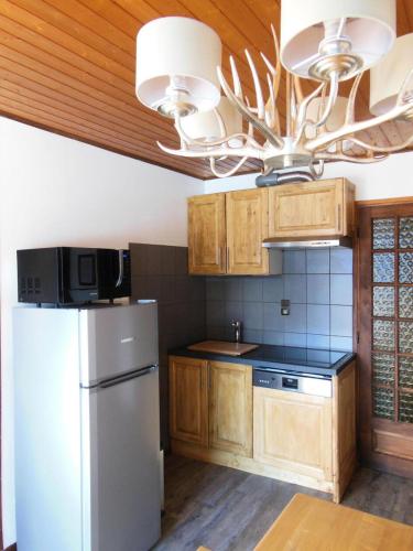 Il comprend une cuisine équipée d'un réfrigérateur blanc et d'un lustre. dans l'établissement Chalet Fleur De Neige - 2 Pièces pour 5 Personnes MAE-3334, à Champagny-en-Vanoise