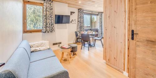 a living room with a blue couch and a table at Résidence Le Centre - 2 Pièces pour 4 Personnes MAE-3338 in Champagny-en-Vanoise