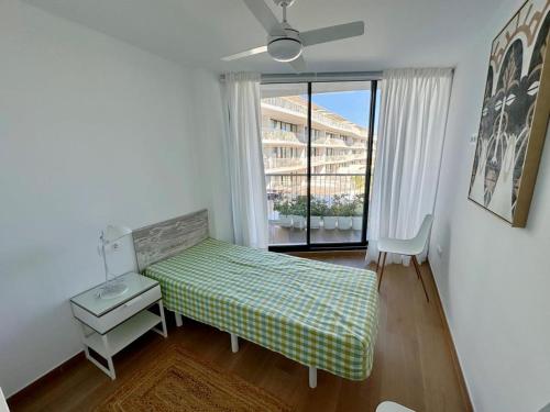 a small bedroom with a bed and a window at Denia Beach 40 in Denia
