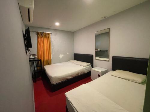 a small room with two beds and a mirror at Hotel Rim Global Subang in Subang Jaya